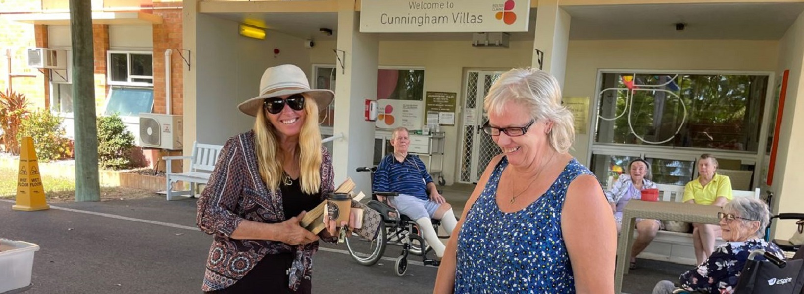 Two ladies smiling while shopping for secondhand books Two ladies smiling while shopping for secondhand books