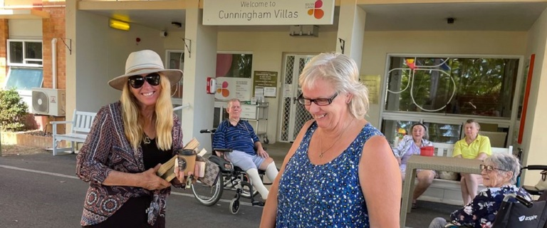 Two ladies smiling while shopping for secondhand books Two ladies smiling while shopping for secondhand books